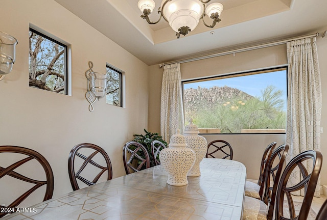 dining space featuring a raised ceiling and a chandelier