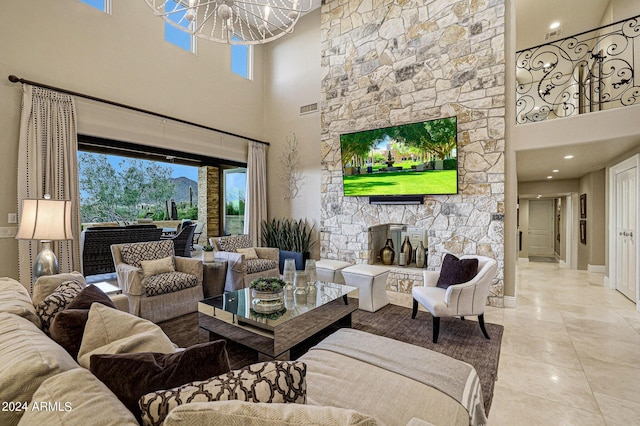 living room with a fireplace, light tile patterned floors, a chandelier, and a high ceiling