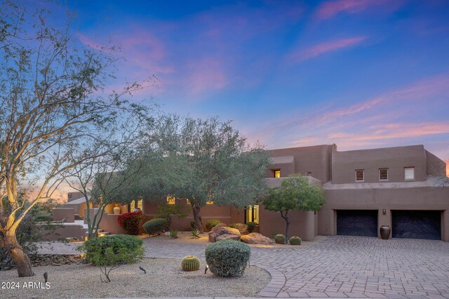 pueblo revival-style home featuring a garage