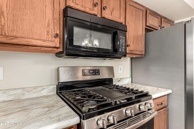 kitchen with stainless steel appliances, light countertops, and brown cabinets