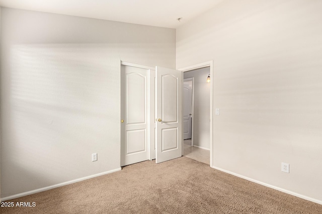 unfurnished bedroom with carpet flooring and baseboards