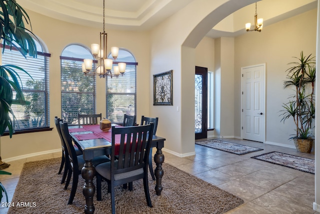 dining area with a raised ceiling, plenty of natural light, and a chandelier