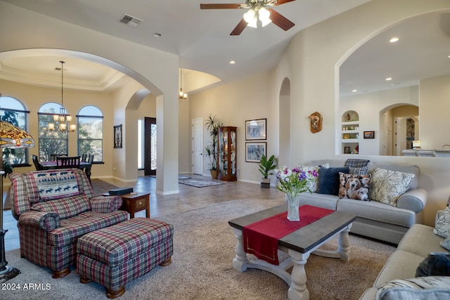 living room with ceiling fan with notable chandelier