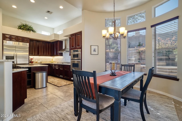 tiled dining room featuring a high ceiling and a notable chandelier