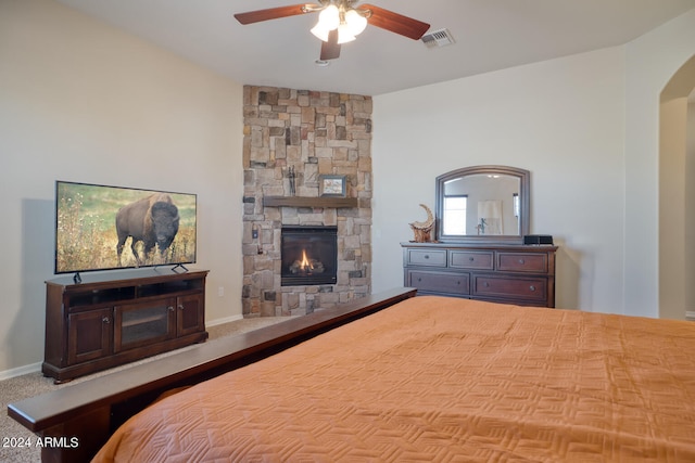 bedroom with a fireplace and ceiling fan