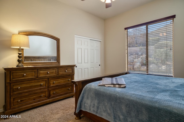 bedroom featuring ceiling fan, light colored carpet, and a closet