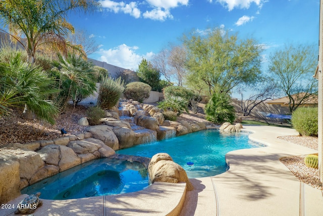 view of pool featuring an in ground hot tub, pool water feature, and a patio area