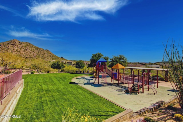 view of jungle gym with a mountain view and a yard