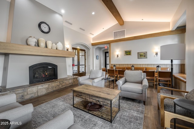 living room with wood-type flooring, a fireplace, and lofted ceiling with beams