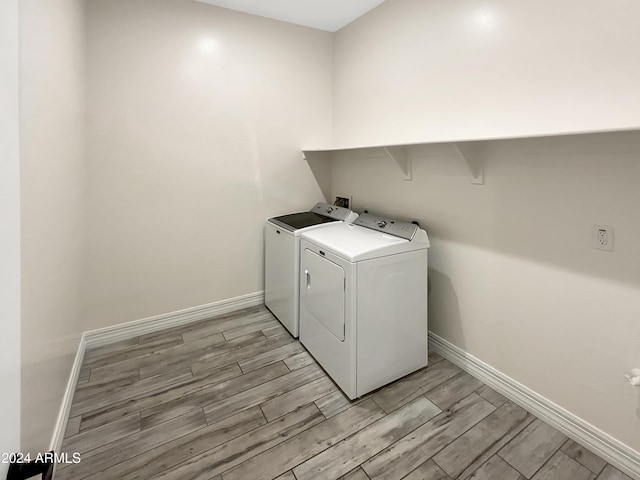 laundry room with independent washer and dryer and light wood-type flooring