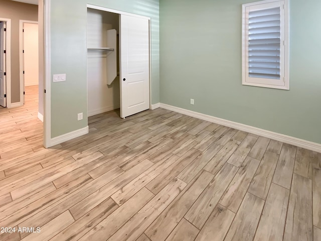 unfurnished bedroom featuring a closet and light wood-type flooring