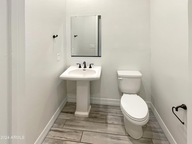 bathroom featuring hardwood / wood-style flooring and toilet