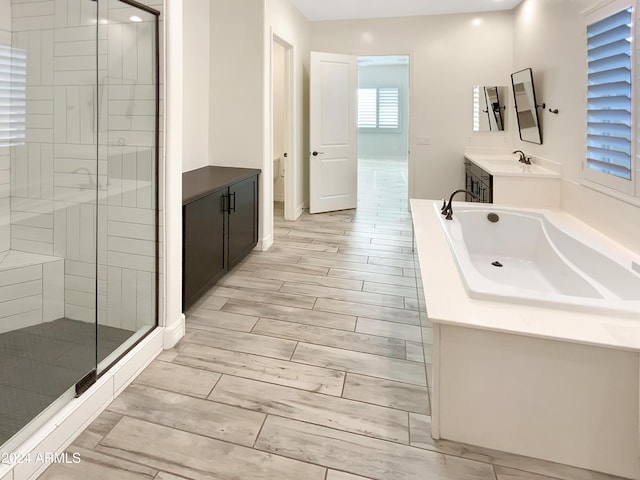 bathroom featuring vanity, hardwood / wood-style flooring, and independent shower and bath