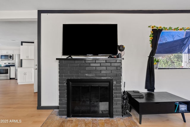 599 W Vah Ki Inn Rd, Coolidge, AZ 85128 - detailed view of appliances with stainless steel finishes, a brick fireplace, and wood finished floors