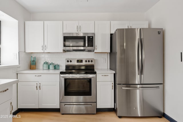 599 W Vah Ki Inn Rd, Coolidge, AZ 85128 - kitchen with appliances with stainless steel finishes, light countertops, white cabinets, decorative backsplash, and light wood-style floors