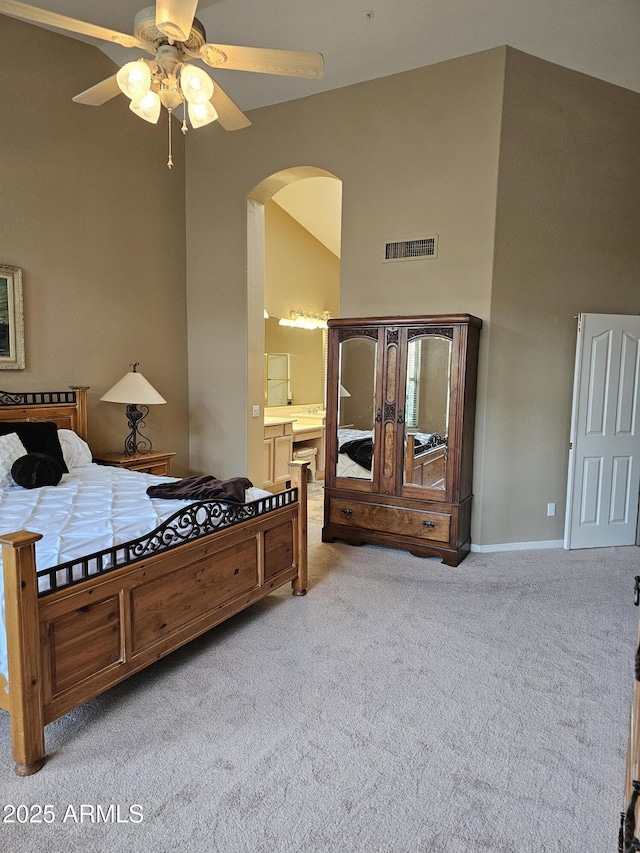 carpeted bedroom featuring vaulted ceiling, ceiling fan, and ensuite bathroom