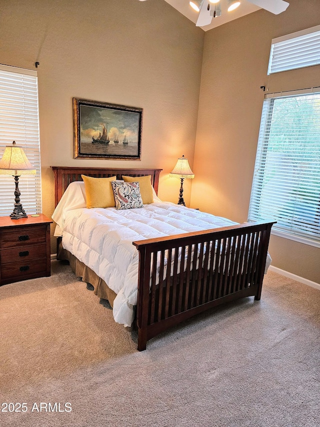 bedroom with ceiling fan, carpet flooring, and multiple windows