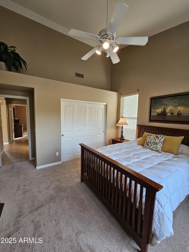 bedroom with ceiling fan, a closet, carpet, and high vaulted ceiling