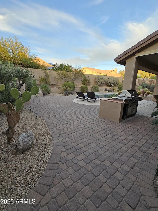 view of patio featuring a grill, an outdoor kitchen, and a mountain view