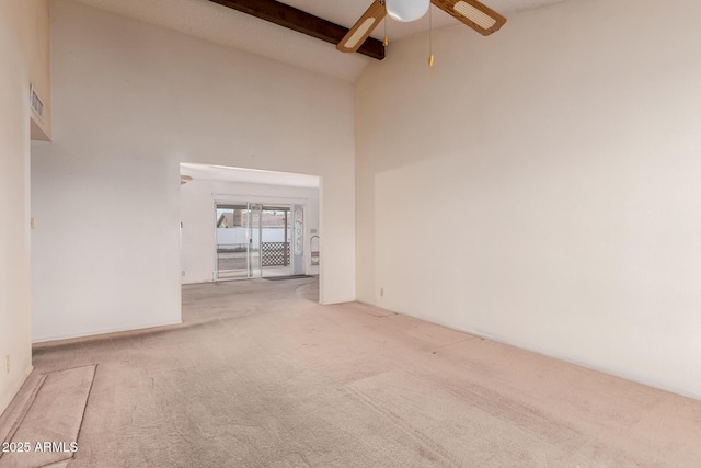 carpeted empty room with ceiling fan, high vaulted ceiling, and beamed ceiling