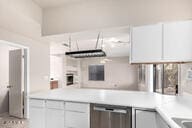 kitchen featuring dishwasher and white cabinets