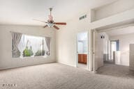 unfurnished living room featuring ceiling fan and vaulted ceiling