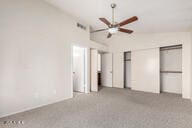 unfurnished bedroom with ceiling fan, light colored carpet, and lofted ceiling