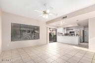 unfurnished living room featuring light tile patterned floors and ceiling fan