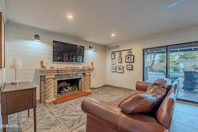 living area featuring recessed lighting, visible vents, a fireplace with raised hearth, and crown molding