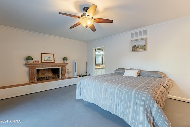 bedroom with visible vents, a fireplace with raised hearth, ceiling fan, ornamental molding, and ensuite bathroom