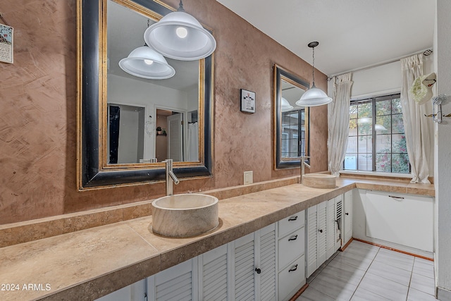 bathroom with vanity, tile patterned floors, and a textured wall