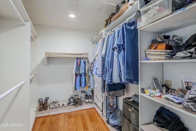 walk in closet with wood finished floors