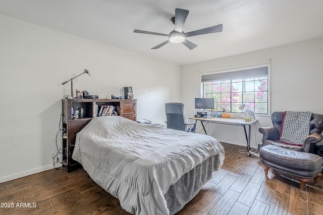 bedroom featuring baseboards, wood finished floors, and a ceiling fan