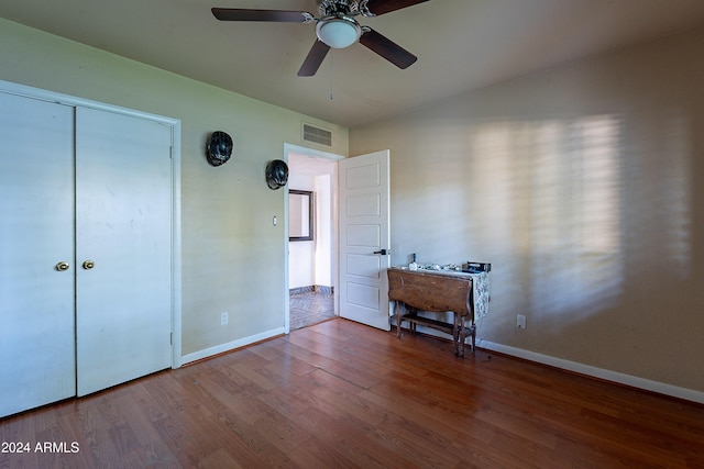 unfurnished bedroom with a ceiling fan, wood finished floors, visible vents, and baseboards