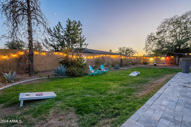 yard at dusk with a fenced backyard