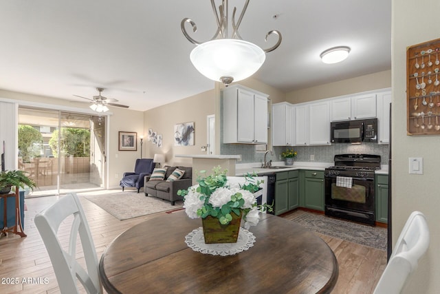 dining area featuring ceiling fan, sink, and light wood-type flooring