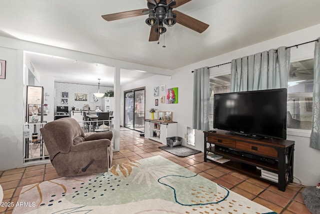 living area featuring ceiling fan and tile patterned floors
