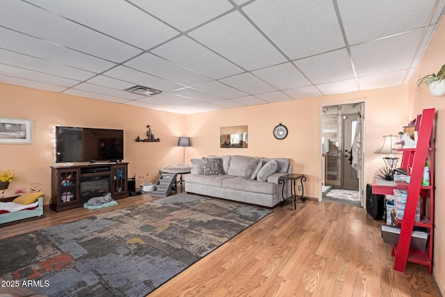 living room with visible vents, a paneled ceiling, and wood finished floors