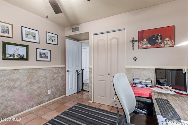 home office with visible vents, wainscoting, ceiling fan, and tile patterned floors