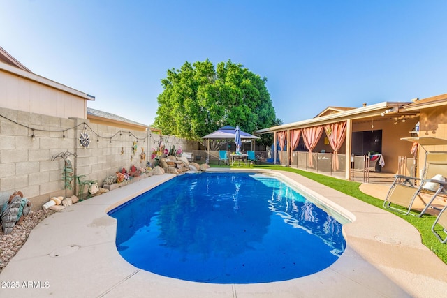 view of pool featuring a patio, a fenced in pool, a fenced backyard, and outdoor dry bar