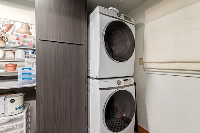 washroom featuring stacked washer / drying machine and laundry area