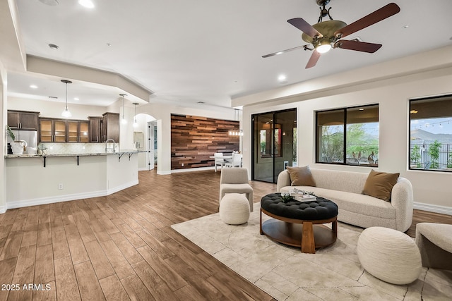 living area featuring baseboards, recessed lighting, ceiling fan, and wood finished floors