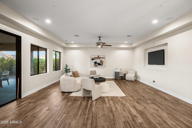 living room featuring ceiling fan, visible vents, wood finished floors, baseboards, and recessed lighting