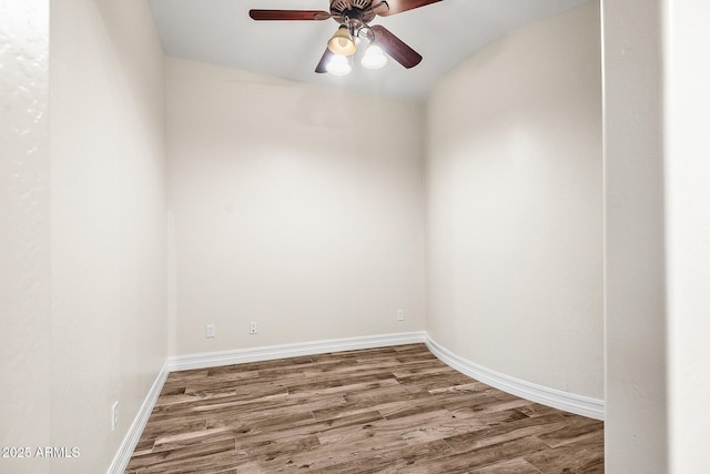 empty room with a ceiling fan, baseboards, and wood finished floors