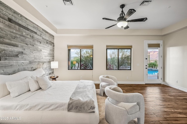 bedroom with multiple windows, access to exterior, wood finished floors, and visible vents