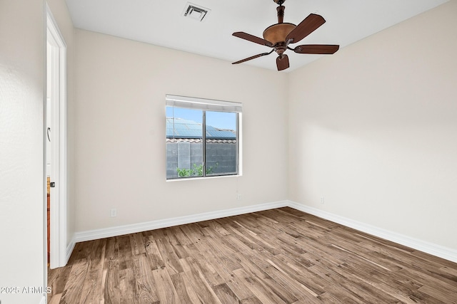 empty room featuring visible vents, baseboards, ceiling fan, and wood finished floors