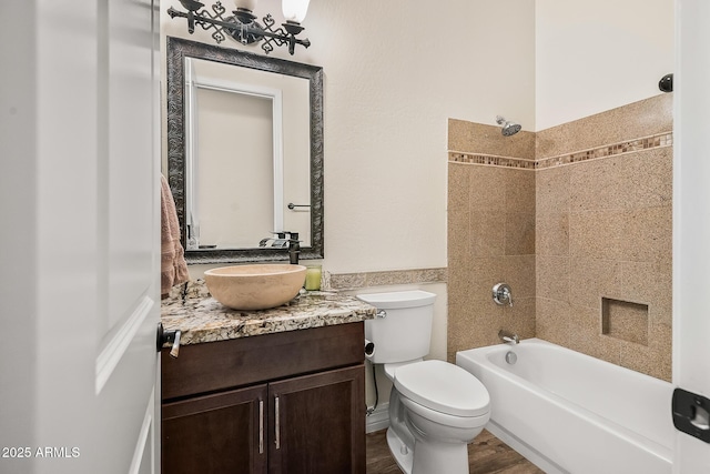 bathroom featuring toilet, shower / bath combination, wood finished floors, and vanity