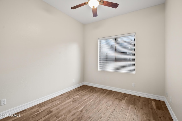 unfurnished room with a ceiling fan, baseboards, and light wood-style floors