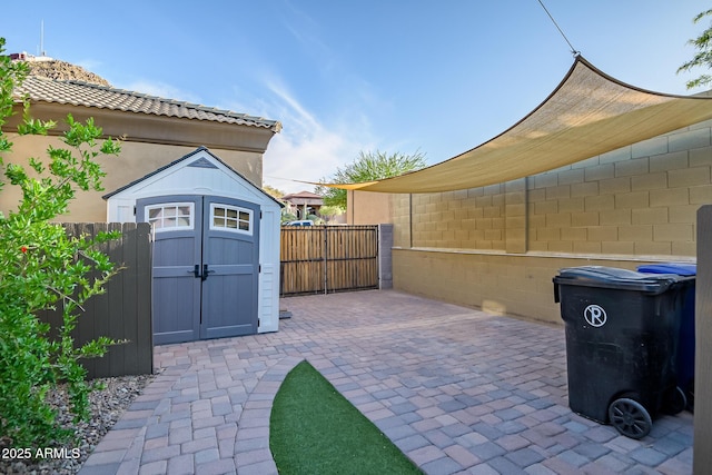 view of patio / terrace featuring a storage unit, an outdoor structure, and fence