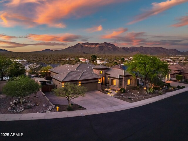 view of front of house featuring concrete driveway, fence, a mountain view, and a garage